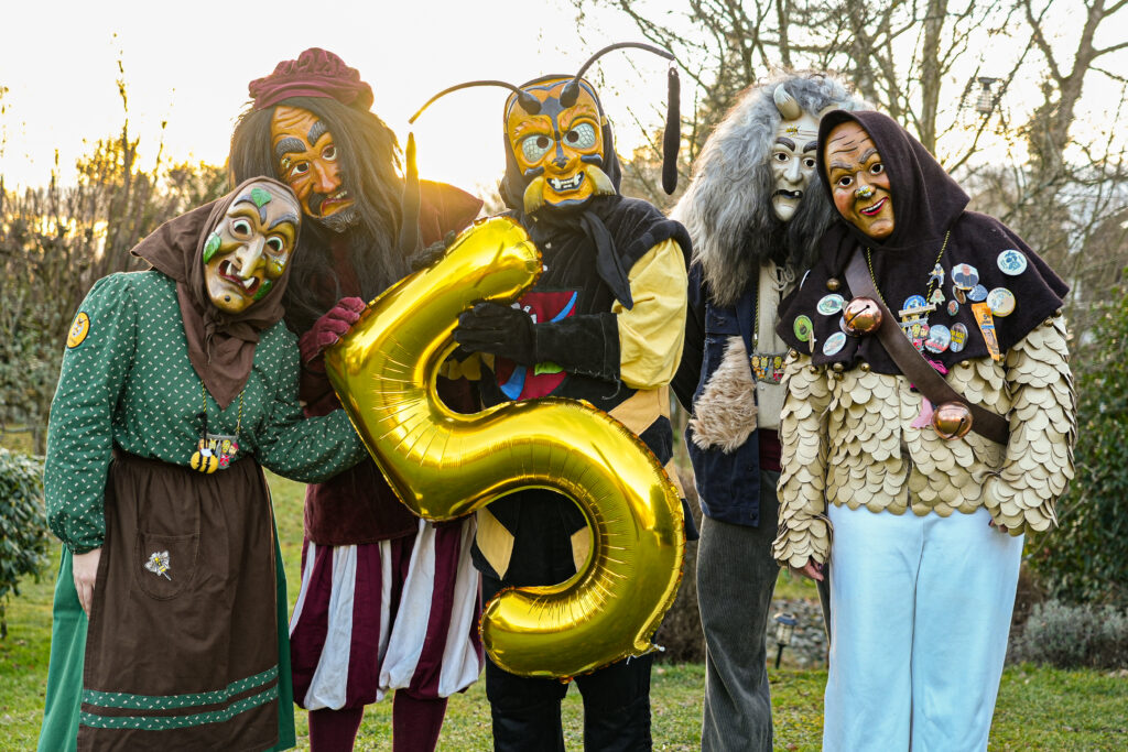 Zu sehen sind die Narrenfiguren mit einem goldenen 5 Jahres-Luftballon